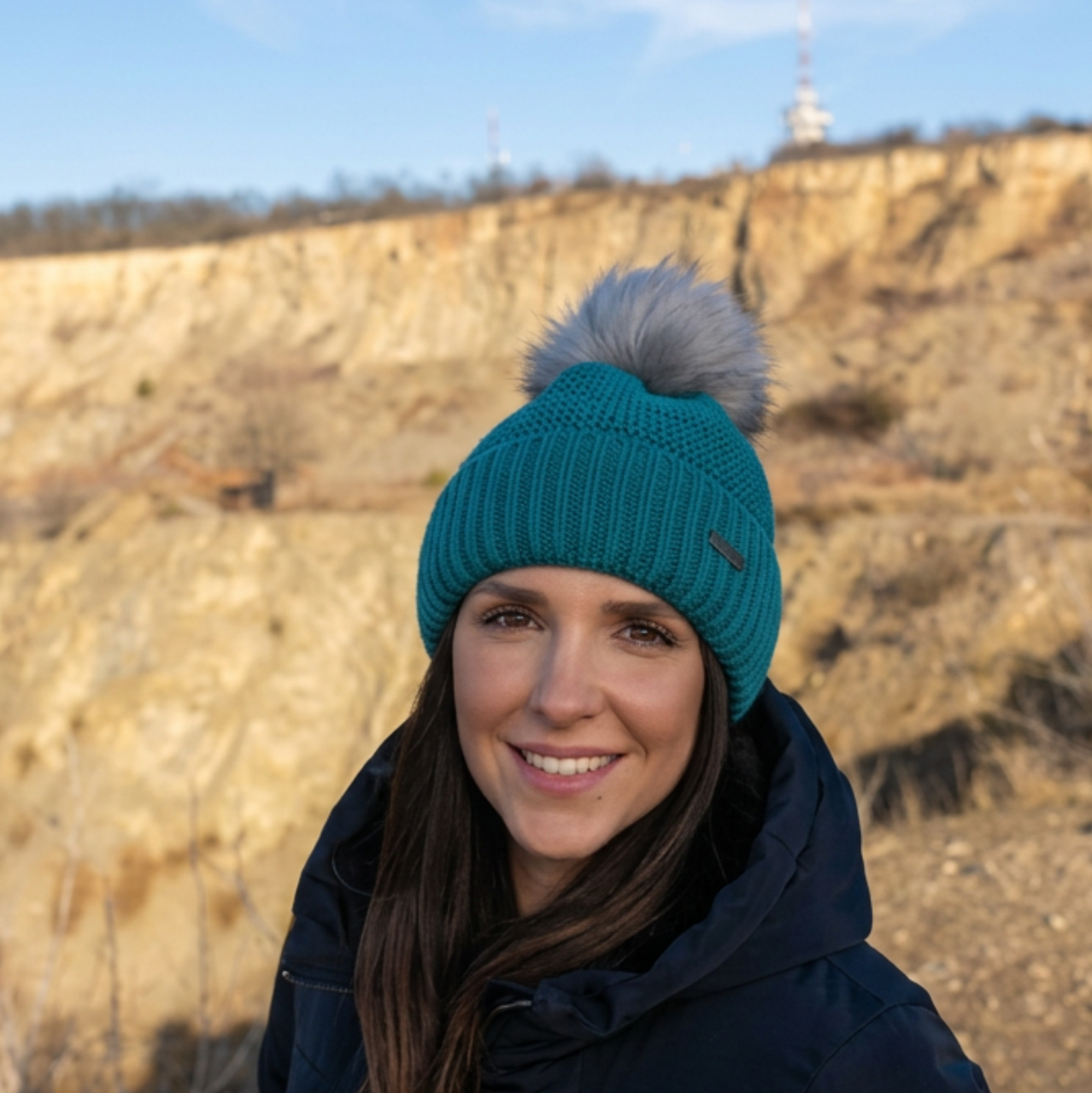 Lady wearing teal Eva bobble hat by SABBOT