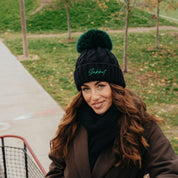Linda black cable knit bobble hat with faux fur pom pom, by Sabbot