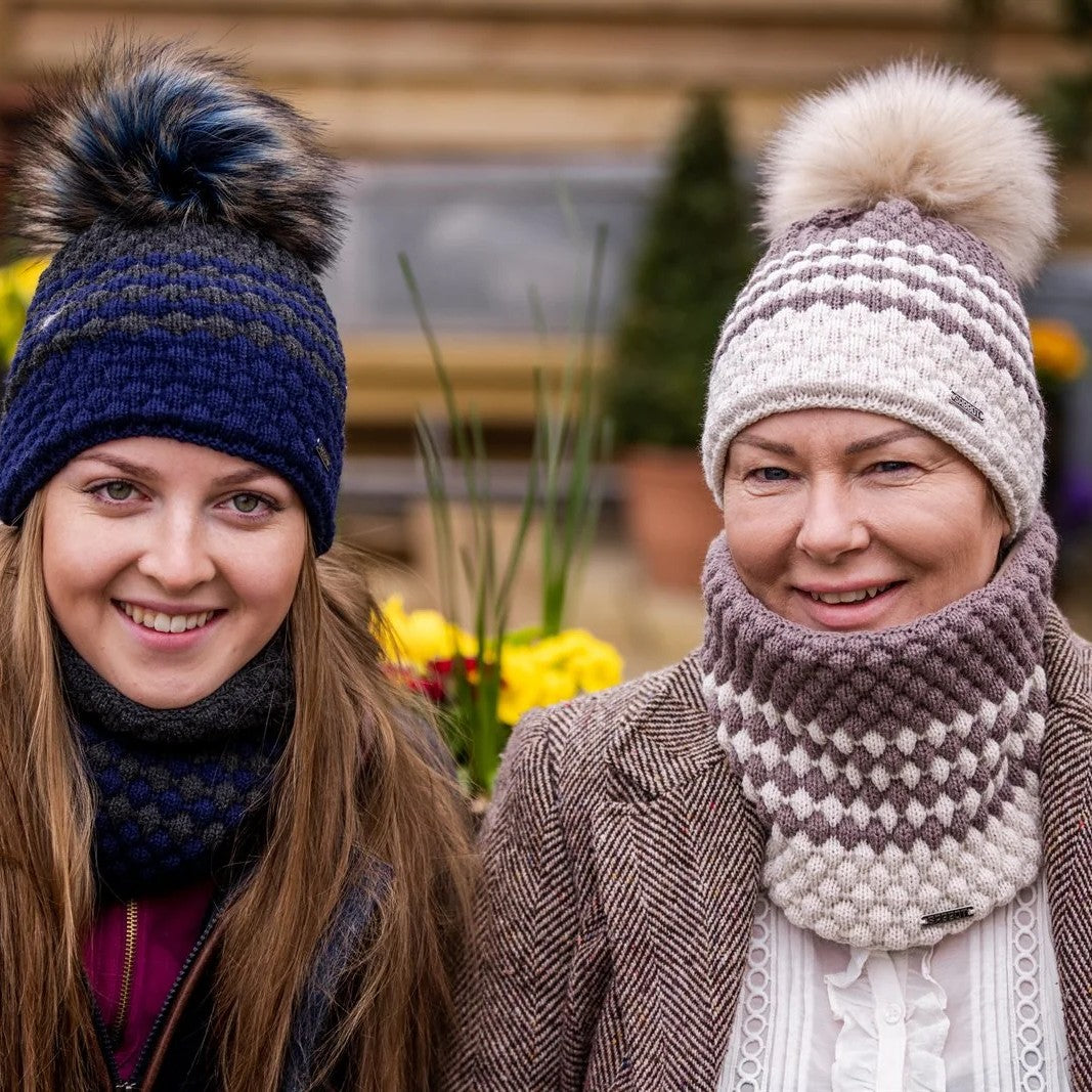 Two women in matching hat and snood sets wearing the Chloe Bobble Hats and Snoods in Navy/Pink and Brown/Cream