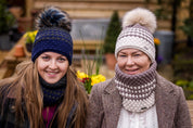 Two women in matching hat and snood sets wearing the Chloe Bobble Hats and Snoods in Navy/Pink and Brown/Cream