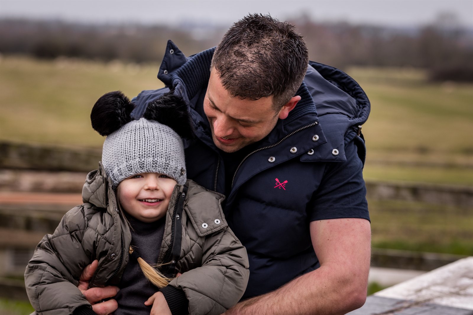 A dad and child on a canal lock wearing the Frankie Childrens Bobble Hat in Light Grey
