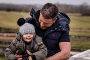 A dad and child on a canal lock wearing the Frankie Childrens Bobble Hat in Light Grey