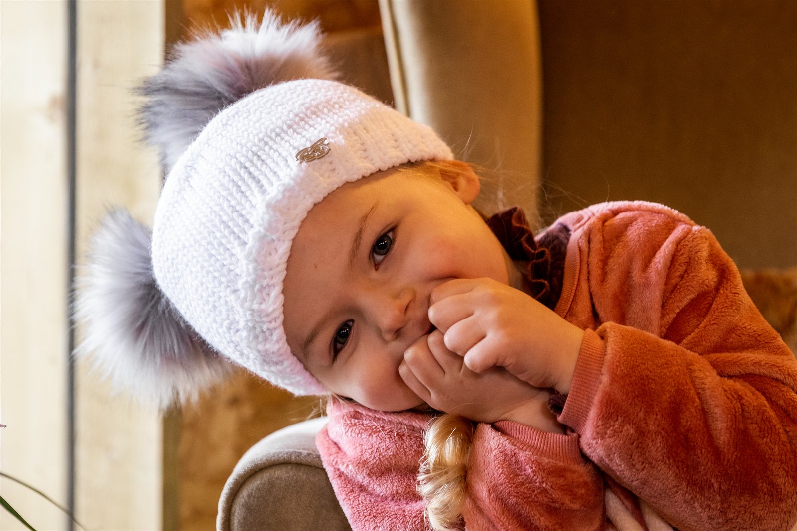 A toddler in a white double pom-pom hat with her mum wearing the Frankie Childrens Bobble Hat in White