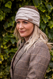 Two women in tweed jackets and riding boots wearing the Linda Headband in Cream