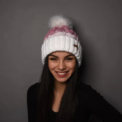 A smiling woman wearing the SABBOT Zuzana Bobble Hat in White/Pink