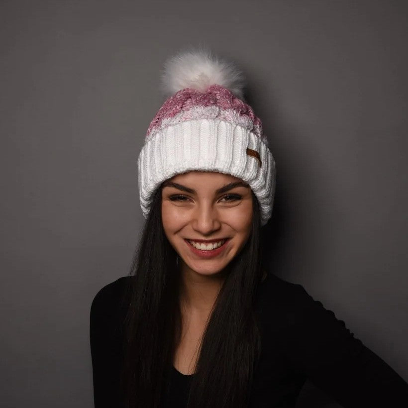 A smiling woman wearing the SABBOT Zuzana Bobble Hat in White/Pink